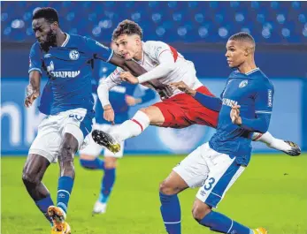  ?? FOTO: GUIDO KIRCHNER/DPA ?? Die frühe Chance zum 1:0 für den VfB: Stuttgarts Youngster Mateo Klimowicz schießt gegen Schalkes Salif Sane und Malick Thiaw, Letzterer allerdings erzielt später die Führung.