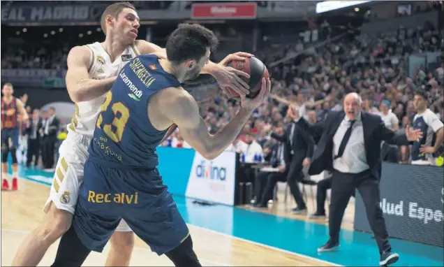  ??  ?? Fabien Causeur trata de arrebatarl­e el balón a Toko Shengelia con Pablo Laso muy atento a la jugada. El pívot georgiano del Baskonia fue clave en el último minuto.