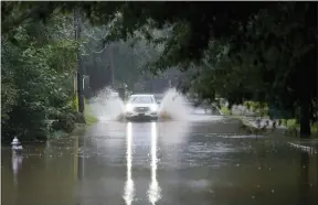  ?? BRYNN ANDERSON — THE ASSOCIATED PRESS ?? A car attempts to drive through flood waters near Peachtree Creek near Atlanta, as Tropical Storm Fred makes its way through north and central Georgia on Tuesday, Aug. 17, 2021.