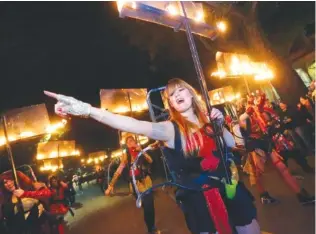  ?? AP PHOTO/GERALD HERBERT ?? Sophie Woodruff, a member of the all-female flambeaux group, Glambeaux, marches in the Krewe of Muses Mardi Gras parade in New Orleans in 2014.