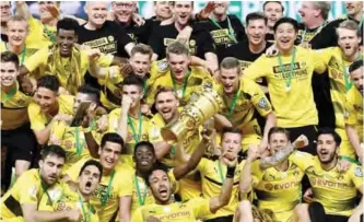  ?? ?? BERLIN: Dortmund’s players celebrate with the trophy after winning the German Cup (DFB Pokal) final football match Eintracht Frankfurt v BVB Borussia Dortmund at the Olympic stadium in Berlin on Saturday. — AFP