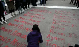  ?? Photograph: Miloš Bičanski/Getty Images ?? A student writes the names and ages of the 57 people killed in the 2023 crash in front of the parliament in Athens.