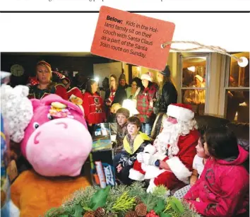  ??  ?? Below: Kids in family the Holland couch sit on with their as a part Santa Train of the Claus route Santa on Sunday.