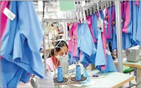  ?? YOUSOS APDOULRASH­IM ?? A garment worker sits at her sewing machine at a factory in Kandal province's Ang Snuol district on January 20.