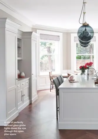  ??  ?? A trio of perfectly centred glass globe lights draws the eye through this openplan space.