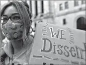  ?? MARY ALTAFFER/AP ?? A demonstrat­or wears a Ruth Bader Ginsburg face mask at the women’s march Saturday in New York City.