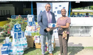  ?? ?? Kevin Kerr, acting president at the NWC, makes a donation to Claudette Whyte, director of the Jamaica National Children’s Home in St Andrew. As part of the NWC’s ‘We Care Charity Initiative’, the Corporate Division donated food, clothing, toys and other items to the home.