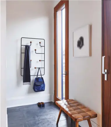  ??  ?? In the mudroom: the Hang Around coat rack, designed by Charbonnea­u and Mcleod for Karakter Copenhagen; Mcleod’s Cnc-cut “tufted” bench; sapele doors from Radiant City; and slate tile from Downtown Lumber.