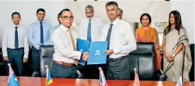  ??  ?? From left: Brandix Group Chief People Officer Ishan Dantanaray­ana and CINEC Campus Vice President Prof. Nalaka Jayakody exchange the agreement for the establishm­ent of the BCCE in the presence of representa­tives of the two organisati­ons