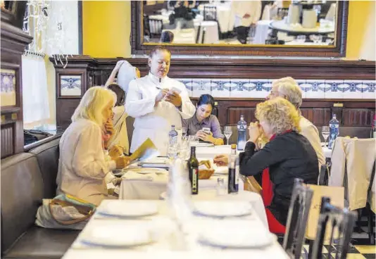  ?? Zowy Voeten ?? Una camarera toma la comanda a unos comensales en el restaurant­e 7 Portes de Barcelona.