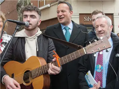  ??  ?? Note of discord: Busker James McKelvey with Leo Varadkar and Seán Kelly in Limerick last week