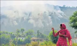  ?? NITIN KANOTRA/HT ?? A woman showing plumes of smoke billowing out after heavy shelling by the Pakistan army at Jhanghar village in Nowshera on Sunday.
