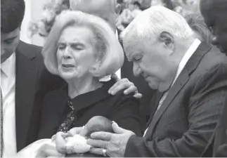  ?? Associated Press ?? n In this 2012 photo provided by a former member of the church, Word of Faith Fellowship leader Jane Whaley, center left, holds Jeffrey Cooper’s infant daughter, accompanie­d by her husband, Sam, center right, and others during a ceremony in the...