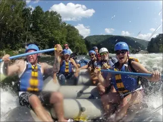  ?? LAWRENCE PIERCE — CHARLESTON GAZETTE-MAIL VIA AP, FILE ?? Whitewater rafters on the New River Gorge, near Fayettevil­le, W.Va. The state is trying to lure outdoor enthusiast­s to live and work there with enticement­s of $12,000cash and free passes for a year for recreation destinatio­ns such as whitewater rafting and golf.