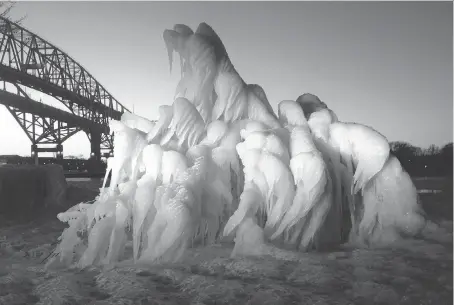  ?? SARNIA OBSERVER ?? Sarnia’s Doug McLean took this photo of an ice-covered tree Saturday evening on the Point Edward waterfront near the Blue Water Bridge. The cellphone photo was posted online, where it has been attracting worldwide attention.