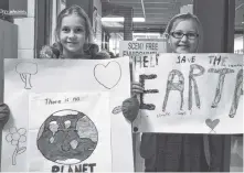  ?? BRENDAN AHERN/THE NEWS ?? Walkout organizers Willow van Lith and Lily Bates holding their signs before the march.