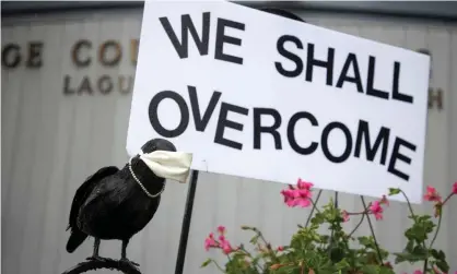  ?? Photograph: Eugene García/EPA ?? A fake bird wearing a face mask and sign encourage passersby during the ongoing Covid-19 pandemic outside the public library in Laguna Beach, California.