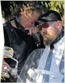  ??  ?? Lorna gives her husband’s bike one last rev while holding his ashes. With her is Lappies Labuschagn­e.