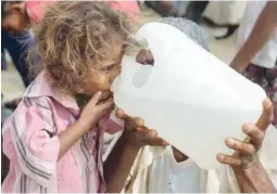  ??  ?? A Yemeni girl drinks water collected from a well in an impoverish­ed village on the outskirts of the port city of Hodeidah. — AFP