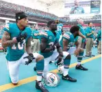  ?? Associated Press file photo ?? ■ Miami Dolphins wide receiver Kenny Stills (10), free safety Michael Thomas (31) and defensive back Chris Culliver (29) kneel during the National Anthem on Oct. 23, 2016, before the first half of an NFL football game against the Buffalo Bills.