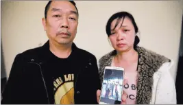  ?? Michael Conroy ?? The Associated Press Ronggao Zhang, left, and Lifeng Ye, display a photo Wednesday of them with their missing daughter, Yingying Zhang, in Urbana, Ind.