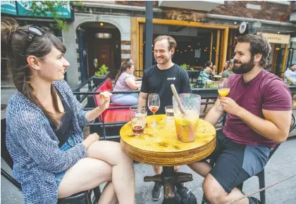  ?? JOHN MAHONEY ?? Pub West Shefford co-owner Maxime Rousseau, centre, speaks to customers on the terrasse of his resto-bar in Plateau-mont-royal after the government gave the go-ahead for bars to reopen yesterday.