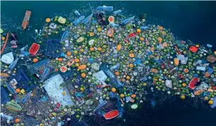  ??  ?? Trash floats next to a rocky coastal area in the Mediterran­ean Sea on the Beirut coastline. —