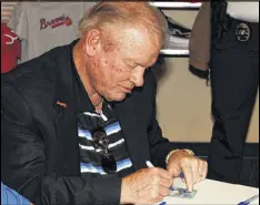  ??  ?? Bob Horner autographs a baseball card at the Mississipp­i Braves Fan Fest in the spring of 2015.