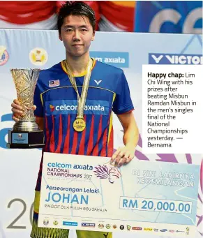  ??  ?? Happy chap: Lim Chi Wing with his prizes after beating Misbun Ramdan Misbun in the men’s singles final of the National Championsh­ips yesterday. — Bernama