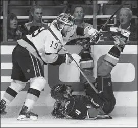  ?? Mark J. Terrill Associated Press ?? DUCKS DEFENSEMAN Cam Fowler, right, falls while under pressure from Kings winger Alex Iafallo, who added an empty-netter as L.A. bested its rival.