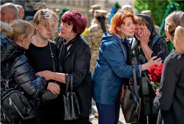  ?? A UKRAINIAN MILITARY SERVICEMEN WHO WAS KILLED IN DONETSK PROVINCE, DURING HIS FUNERAL IN LVIV, ON SATURDAY. — ap ?? Relatives react next to the coffin of Pankratov Oleksandr, 49,