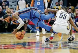  ?? [AP PHOTO] ?? Oklahoma City’s Paul George, left, and New Orleans’ E’Twaun Moore battle for the ball during Monday night’s NBA game at Smoothie King Center in New Orleans.