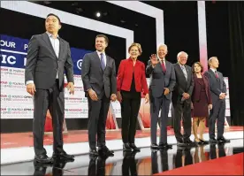  ?? MARIO TAMA / GETTY IMAGES ?? Democratic presidenti­al candidates (from left) Andrew Yang, South Bend Mayor Pete Buttigieg, Sen. Elizabeth Warren, former Vice President Joe Biden, Sen. Bernie Sanders, Sen. Amy Klobuchar and Tom Steyer await the start of the Democratic presidenti­al primary debate at Loyola Marymount University on Dec. 19 in Los Angeles. Seven candidates out of the crowded field qualified for the sixth and final Democratic presidenti­al primary debate of 2019.