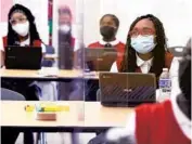  ??  ?? Seventh-grade student Zarrhea Johnson and her fellow classmates watch an educationa­l film.