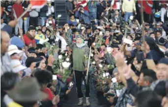  ?? AP/ ?? Los manifestan­tes sostienen flores por sus compañeros fallecidos.