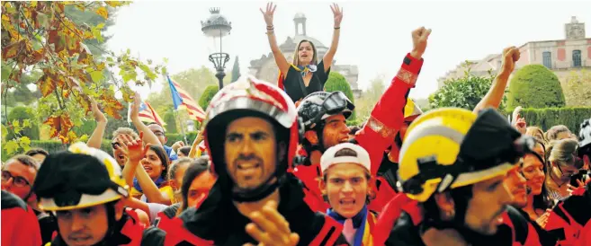  ??  ?? Firemen and students protest near Barcelona’s parliament as Catalonia prepares to cast itself adrift from the rest of Spain