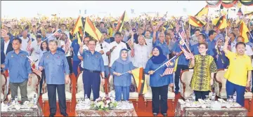  ??  ?? Abang Johari (front, third left) – flanked by his wife Datin Patinggi Dato Juma’ani Tuanku Bujang and Morshidi – joins others in waving flags during the ‘Sejiwa Senada’ programe in Batu Kawah. Also seen are Abdul Karim (front, left), Rohani (front,...