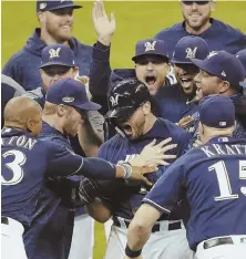  ?? AP PHOTO ?? MILWAUKEE’S BEST: Mike Moustakas is swarmed by Brewers teammates after his single in the 10th inning beat the Rockies, 3-2, in last night’s NLDS Game 1.