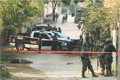  ??  ?? Militares y policías resguardan uno de los cadáveres que dejó la violencia en el puerto turístico.