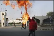  ?? NIRANJAN SHRESTHA — THE ASSOCIATED PRESS ?? A Nepalese protester burns an effigy of Khadga Prasad
Oli, the country’s prime minister, in front of the parliament building in Kathmandu on Sunday.