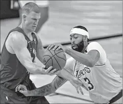  ?? MARK J. TERRILL/AP ?? Nuggets’ Mason Plumlee, left, and Lakers’ Anthony Davis compete for control Friday.