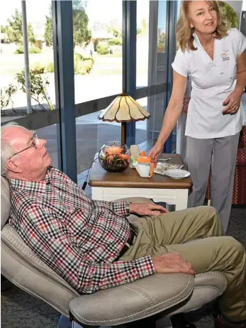  ?? PHOTO: BEV LACEY ?? DEVICE FUNDED: Volunteer Mick O’Mara tries the RoseCup with one of the designers, Hannelie Roux.