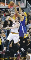  ?? RON SCHWANE/THE ASSOCIATED PRESS ?? Golden State Warriors centre JaVale McGee scores over Cleveland Cavaliers forward Kevin Love on Wednesday in Cleveland.