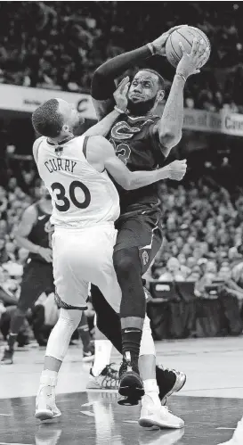  ?? [AP PHOTO] ?? Cleveland’s LeBron James is called for a charge against Golden State’s Steph Curry in Game 4 of the NBA Finals.