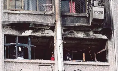  ?? [ FOTO EPA ] ?? Pegawai bomba melihat kerosakan pada bangunan selepas berlaku kebakaran di Hospital Taipei di Hsinchuang, New Taipei
City, Taiwan, semalam.