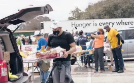  ?? MARIE D. DE JESUS/HOUSTON CHRONICLE ?? Enrique Albi of the Houston Food Bank loads food into a vehicle Sunday in the aftermath of frigid temperatur­es that hit Texas last week. Hospitals in the state and throughout the South are struggling with water shortages.