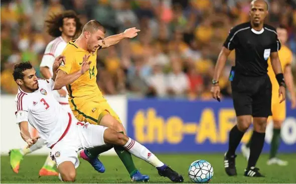  ?? EPA PIC ?? Australia’s James Troisi (centre) is challenged by the United Arab Emirates’ Walid Abbas at the Sydney Football Stadium yesterday.