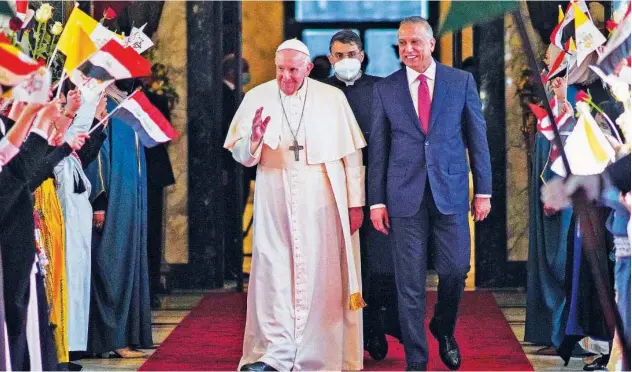  ?? Agence France-presse ?? ↑
Mustafa Al Kadhemi (right) welcomes Pope Francis at the Baghdad Airport on Friday.