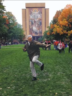  ?? Courtesy Martha Jenkins ?? Chronicle columnist Bruce Jenkins strikes a Heisman pose in front of “Touchdown Jesus” during a birthday trip to the Notre Dame campus.