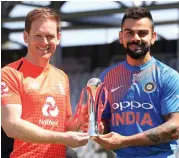  ?? — AP ?? England captain Eoin Morgan ( left) and his India counterpar­t Virat Kohli pose with the T20 series trophy at Old Trafford in Manchester on Monday.
